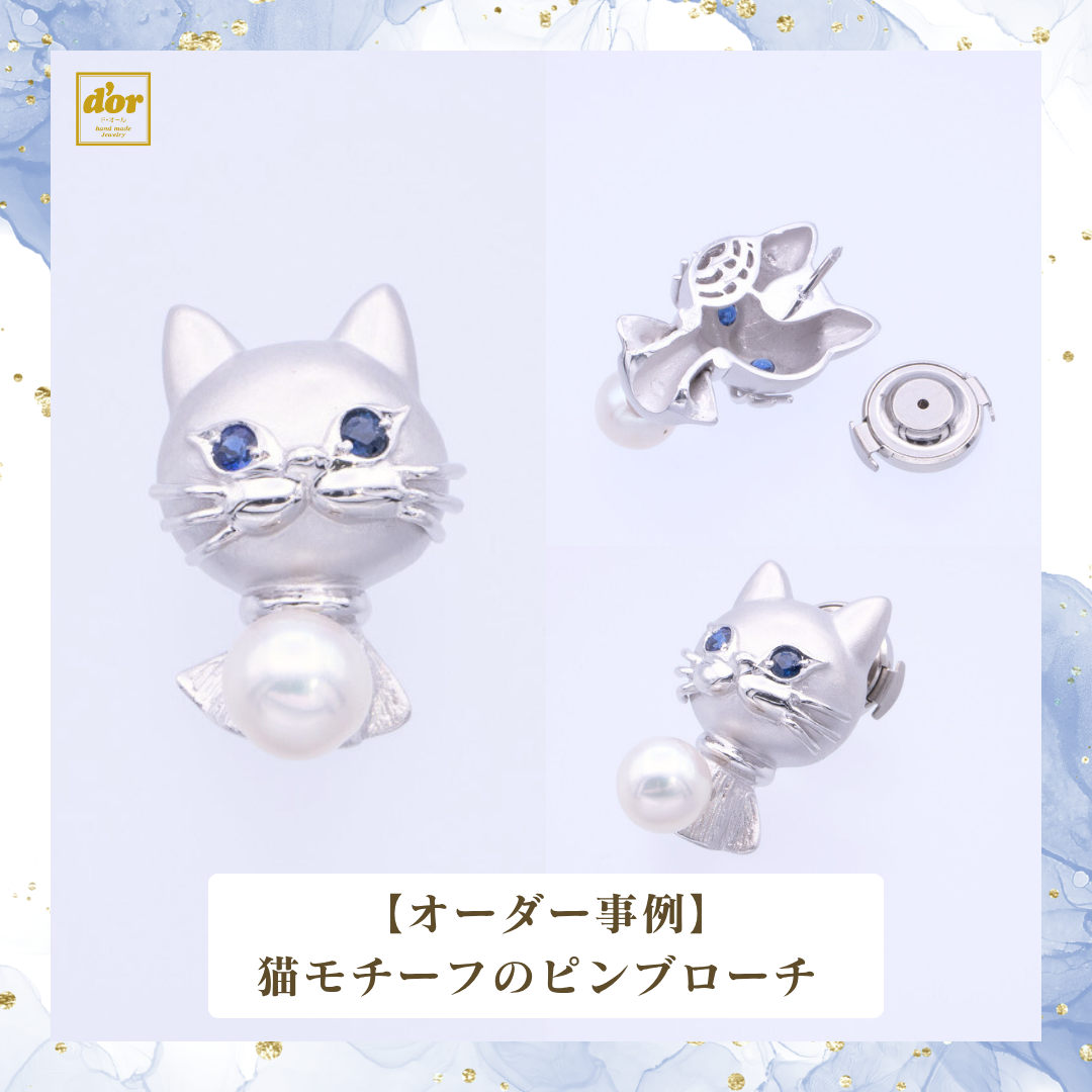 猫をモチーフにしたシルバー製ピンブローチ。ブルーサファイアの瞳とパールをあしらったオーダージュエリー。